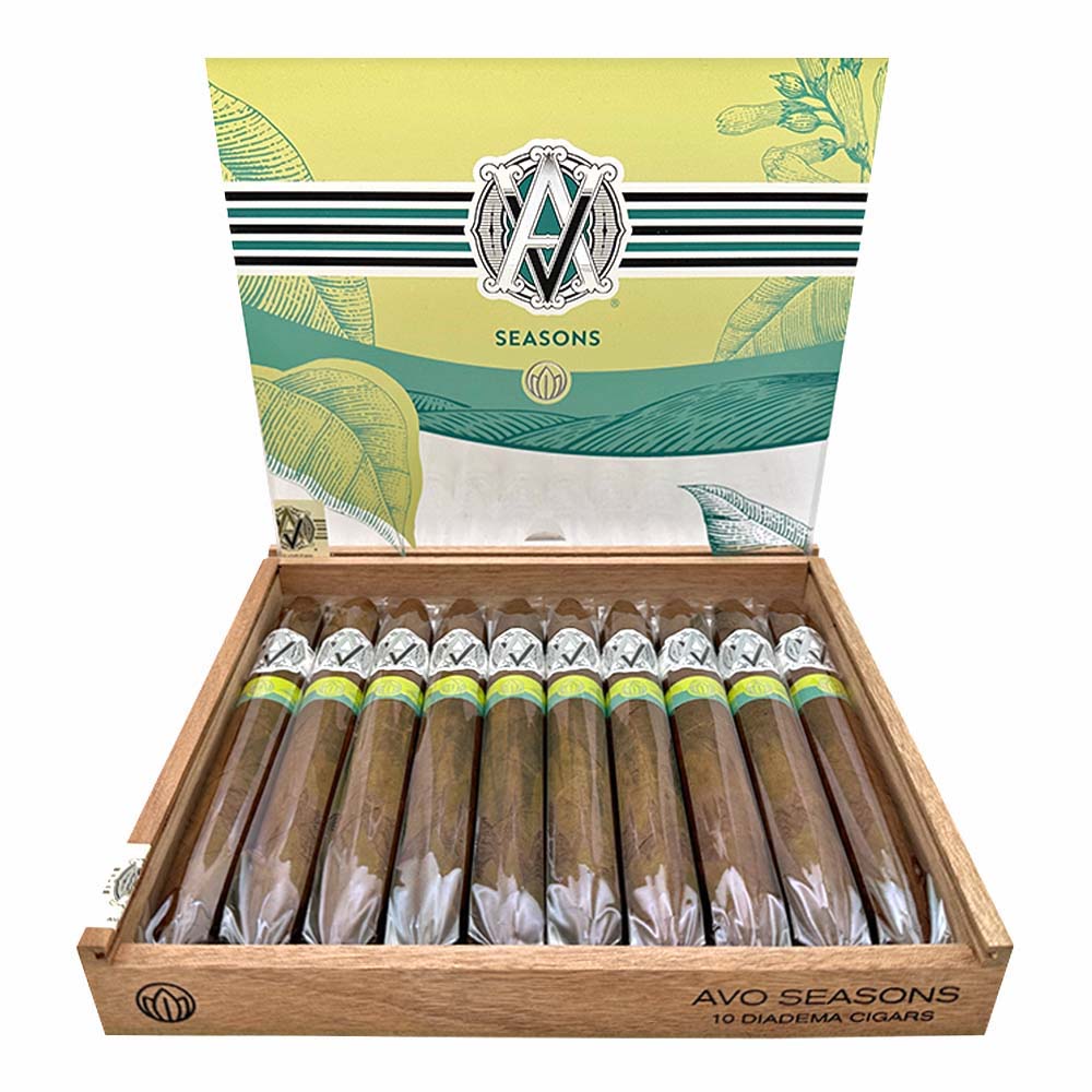 Open box of AVO Seasons cigars with 10 diadema cigars displayed, featuring elegant packaging design with green and yellow accents.