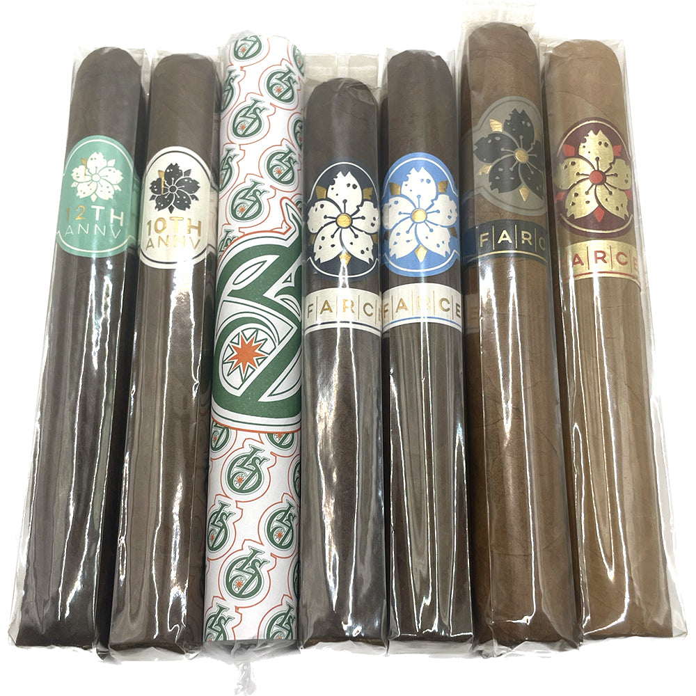 A selection of seven cigars, each wrapped with distinctive labels featuring various designs and brand markings, displayed in a row.