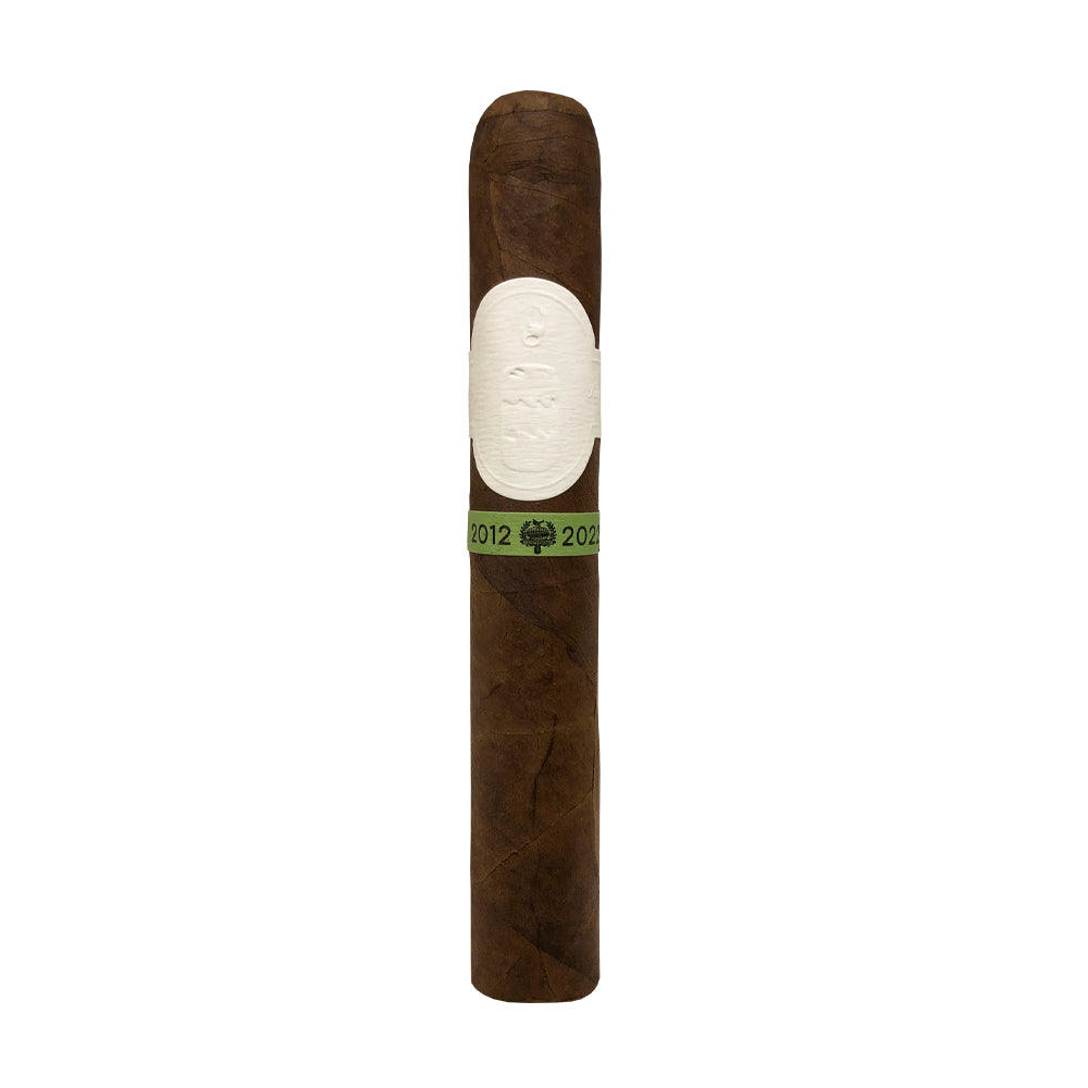 Brown cigar with a white and green band featuring a tree logo and the years 2012 to 2022.